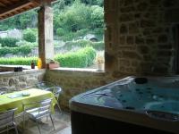 a bath tub in a room with a table and chairs at Chambre Comballe charmante avec jacuzzi in Sanilhac