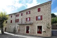 a large brick building with red windows and a balcony at Chambre Comballe charmante avec jacuzzi in Sanilhac