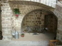 a patio with a table and chairs in a stone wall at Chambre Comballe charmante avec jacuzzi in Sanilhac