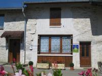 a stone building with windows and flowers in front of it at Murmure des buis in Corveissiat