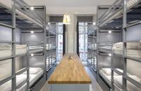 a room with multiple bunk beds with a wooden table in the middle at Astor Hyde Park Hostel in London