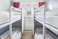 a room with three bunk beds with a window at Astor Hyde Park Hostel in London
