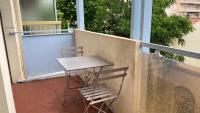 a table and two chairs sitting on a balcony at Le Goeland 3 ,balcon petite vue mer latérale au 3 eme étage sans ascenseur in Toulon