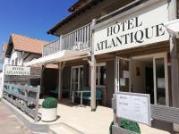 a hotel entrance with a sign in front of a building at Hotel Atlantique in Mimizan-Plage