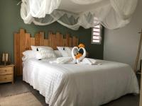 a bedroom with two swans towels on a bed at Gîte Maracudja vue sur mer in Capesterre-Belle-Eau