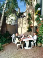 two people sitting at a table in front of a building at Hotel de Bourgogne in Saulieu