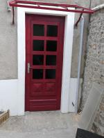 a red door on the side of a building at Paille de blé in Courbouzon