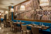 un restaurante con mesas y sillas y una gran pintura en la pared en Vila Galé Collection Serra da Estrela, en Manteigas