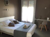 a bedroom with a white bed with a window at Crystal Hotel in Royan
