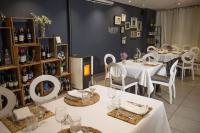 un restaurante con mesas y sillas blancas y botellas de vino en Savoy, en Alcoy