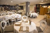 Un comedor con mesas blancas y sillas blancas. en Savoy, en Alcoy