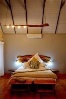a bedroom with a large bed with two pillows at Addo Dung Beetle Guest Farm in Addo