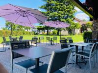 a group of tables and chairs with pink umbrellas at Kyriad Hotel Meaux in Meaux