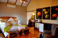 a bedroom with a bed and a couch in a room at Addo Dung Beetle Guest Farm in Addo