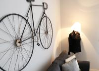 Una bicicleta colgada en una pared junto a un sofá en HABITAT Nafplio bnb - Design Apartment, en Nauplia