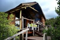 a log cabin with a table and chairs on a deck at Addo Dung Beetle Guest Farm in Addo
