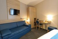 a living room with a blue couch and a desk at Hotel Restaurant Le Coquelicot in Burnhaupt-le-Haut