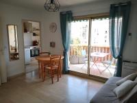 a living room with a table and a kitchen with a patio at Le Palais Royal in Saint-Raphaël