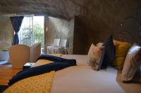 a bedroom with a bed with yellow and blue pillows at Addo Dung Beetle Guest Farm in Addo