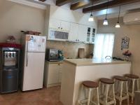 a kitchen with a refrigerator and a counter with stools at Beautiful Life B&amp;B in Dongshan