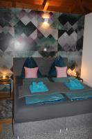 a bedroom with a bed with pink and blue pillows at Penthouse Skyview im Natur-Erlebnispark Bad Kleinkirchheim in Patergassen