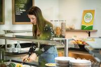 Rossleithen古特恩哈根假日酒店的站在厨房准备食物的妇女