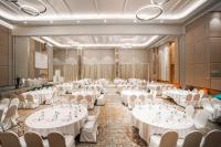 a banquet hall with white tables and chairs at HARRIS Hotel Batam Center in Batam Center
