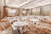 a banquet hall with white tables and chairs at HARRIS Hotel Batam Center in Batam Center