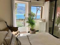 a bedroom with a bed and a large window at Le Jardin d&#39;Emile in Cassis