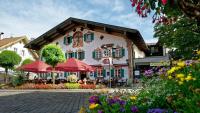 a building with umbrellas and flowers in front of it at Hotel Alte Post in Oberammergau