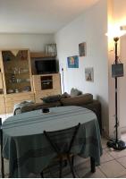 a living room with a table and a couch at Appartement sympa Arcachon in Arcachon