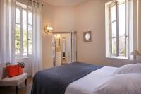 a bedroom with a large bed with a red bag on it at Château Les Carrasses in Capestang