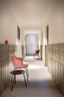 a corridor with two chairs in a hallway at Hotel Augustyn Brugge in Bruges