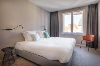 a bedroom with a large white bed and a window at Hotel Augustyn Brugge in Bruges