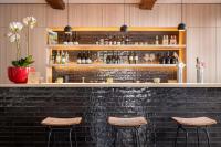 a bar with two stools in front of a brick wall at Hotel Augustyn Brugge in Bruges