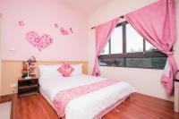 a bedroom with a bed with pink hearts on the wall at 甘丹民宿-三義火車站前 in Sanyi