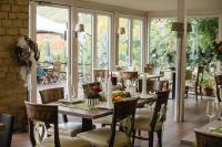 a dining room with a table and chairs and windows at Weingut und Gästehaus Zilliken in Nittel