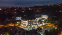 カンポス・ド・ジョルドンにあるHotel Leão da Montanhaの夜間にプールを目の前に設置した大きな建物