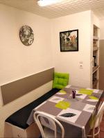 a table and chairs in a room with a table and a clock at Appartement T1 quartier château de Pau in Pau