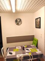 a table with a green chair and a clock on a wall at Appartement T1 quartier château de Pau in Pau