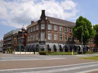 Un gran edificio de ladrillo al costado de una calle. en Hotel Wilhelmina, en Venlo