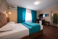 a bedroom with a large bed with blue curtains at Vila Levent Mangalia in Mangalia
