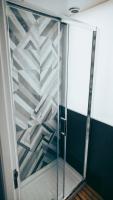 a shower with a glass door in a room at Gspot Hostels & Love Triangles Pizzeria in Lisbon