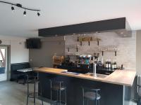 a kitchen with a bar with stools in it at Bar du Marché - Hôtel - Restaurant in Langeais