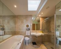 a bathroom with a tub and a sink at Bavaria Lifestyle Hotel in Altötting