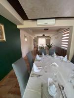 KakanjにあるMotel Tironの白いテーブルと椅子のあるダイニングルーム