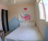 a bedroom with a bed with a picture of an elephant at 萩閣民宿Sara&#39;s House走路可到夜市近市區好停車 in Hualien City