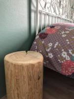 a wooden stool next to a bed with a wooden log next to it at Domaine Saint Esselin in Larreule