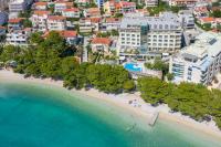 an aerial view of a beach with trees and buildings at Hotel Park Makarska in Makarska