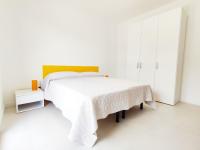Dormitorio blanco con cama blanca y mesa en QUITO - Dietro Piazza Mazzini - Immobil Relax, en Lido di Jesolo